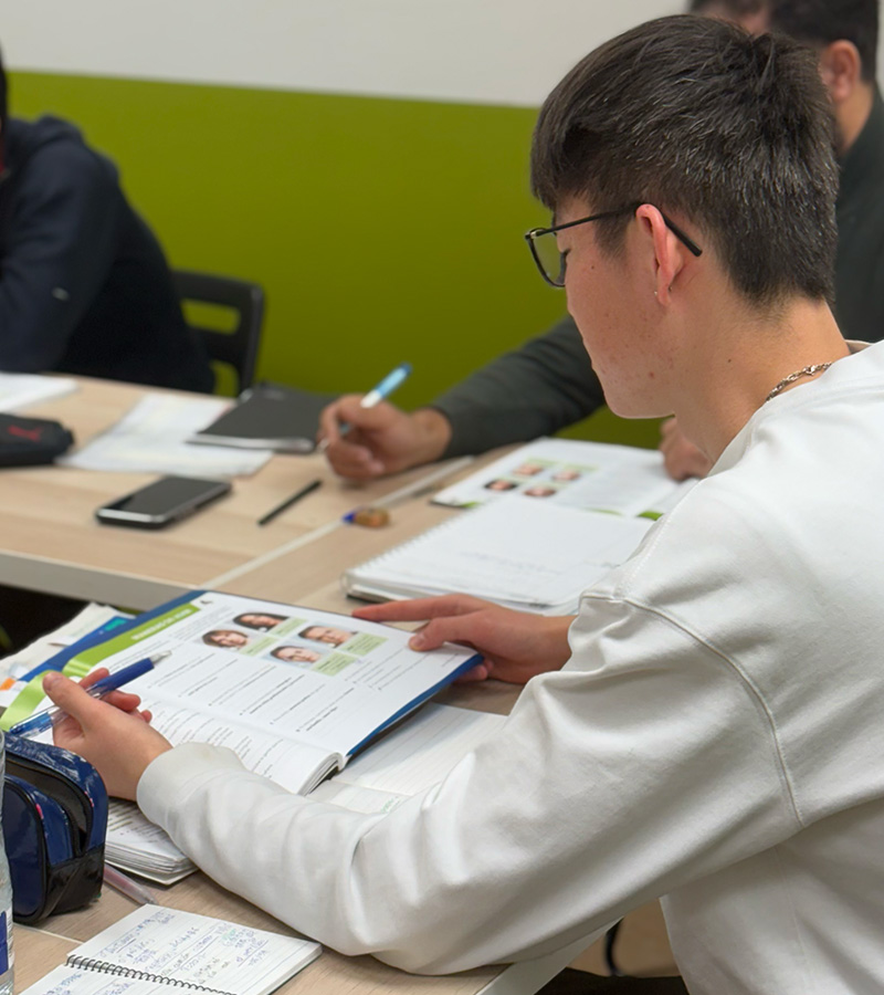 Focused student working with course materials during intensive Spanish courses in Madrid